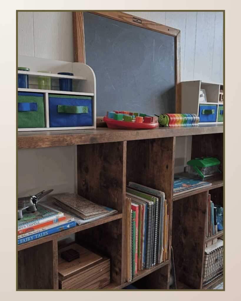 Wooden shelving unit holds colorful storage bins, books, and a chalkboard, creating an organized and inviting space.