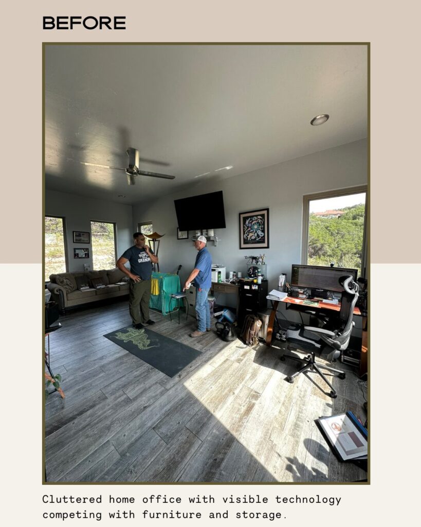 Cluttered home office with a couch, storage, and technology; two people discussing amidst disorganized space and lighting.